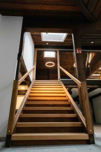 Holztreppe mit Sicht auf Dachfenster – natürliches Licht und warme Materialien im Innenausbau
