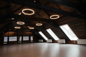 Großer Saal mit Holzbalkendecke und Dachfenstern – hell und einladend für Events und Feiern